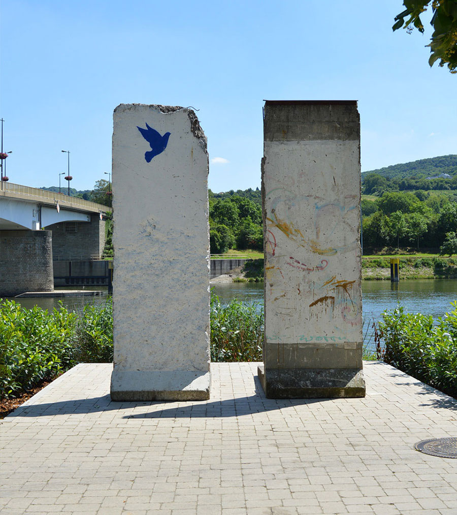 Original segments of the Berlin Wall on the banks of the Moselle in Schengen with the painting of a blue dove of peace.